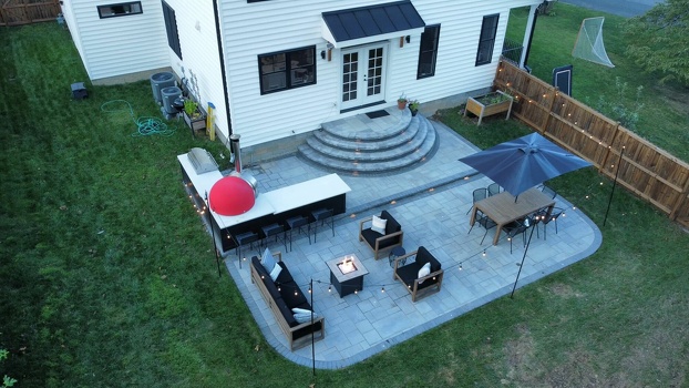 l shaped grill island with pizza oven and bar seating on patio in plank charcoal finish