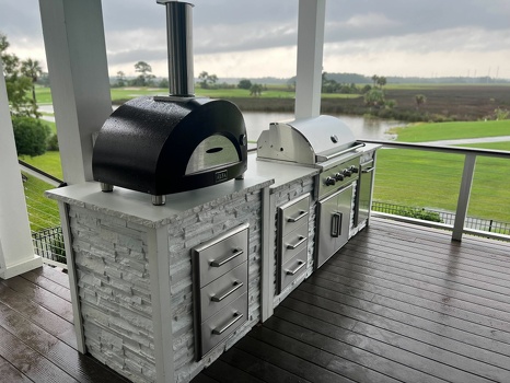 linear grill island with pizza oven and storage drawers on deck in stacked stone chalk finish-3