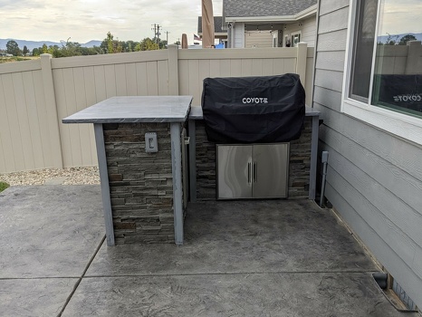 l shaped grill island with coyote grill cover on pation in stacked stone graphite finish-2