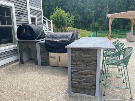 l shaped grill island with pizza oven and bar seating on patio in stacked stone graphite finish-3