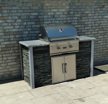 linear grill island with double access doors on patio in stacked stone graphite finish