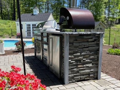 linear grill island with pizza oven combo storage and refrigerator on patio in stacked stone graphite finish-4