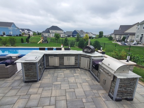 u shaped grill island with storage drop in cooler power burner and pizza oven on patio next to pool lon stacked stone graphite finish-2