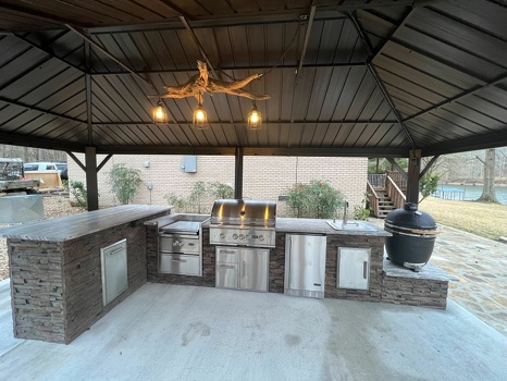 l shaped outdoor kitchen with power burner refrigerator and combo storage with asado stand on patio in stacked stone terra finish-1