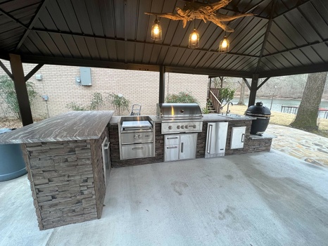 l shaped outdoor kitchen with power burner refrigerator and combo storage with asado stand on patio in stacked stone terra finish-2