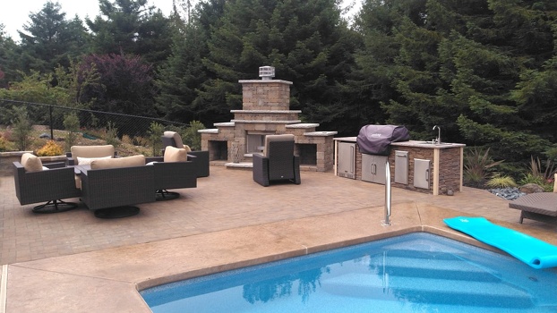 linear grill island with coyote grill cover and refrigerator on patio next to pool in stacked stone terra finish-3