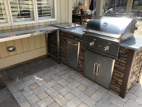 linear grill island with drop in cooler and pull out trash in stacked stone terra
